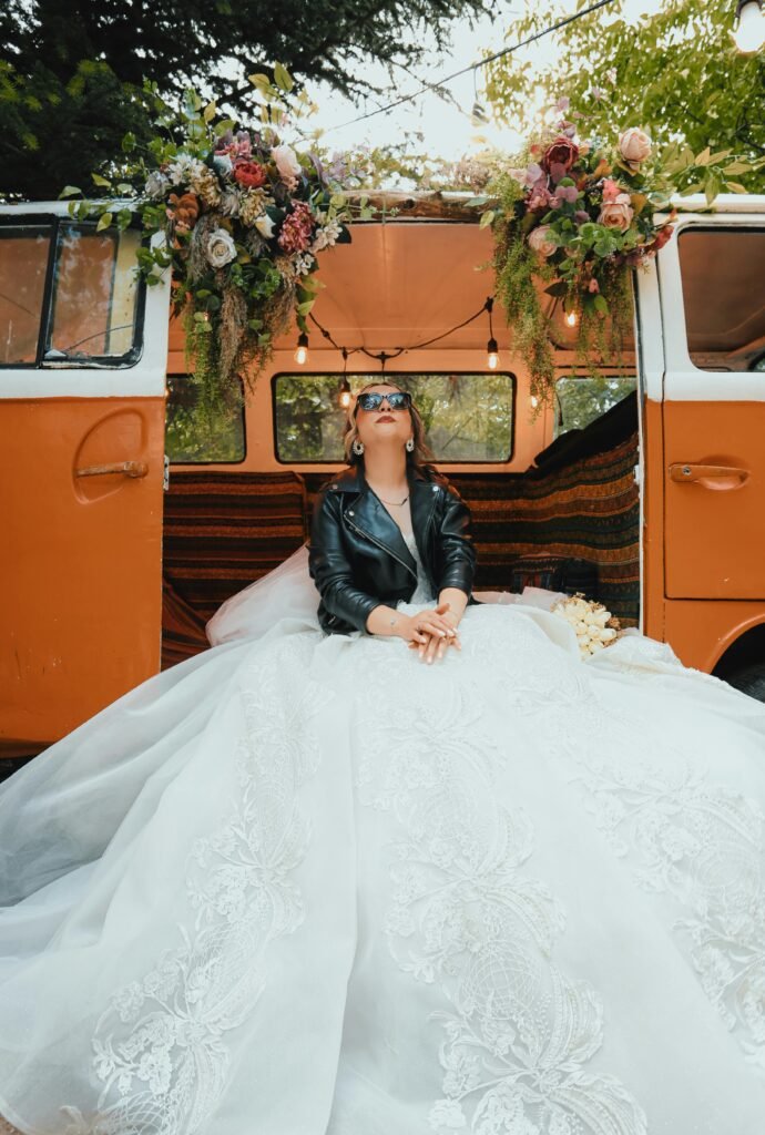Unique bridal portrait with a leather twist by a flower-decorated van in Ankara, Türkiye.